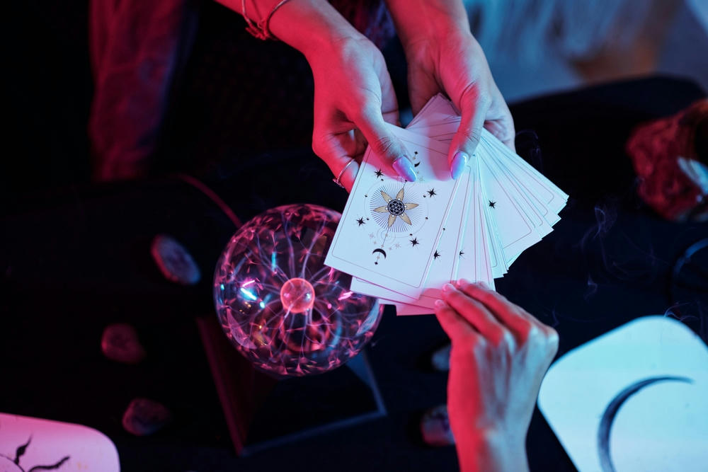 Hands of a woman choosing a tarot card in the hands of a fortune teller to get an answer to her question.