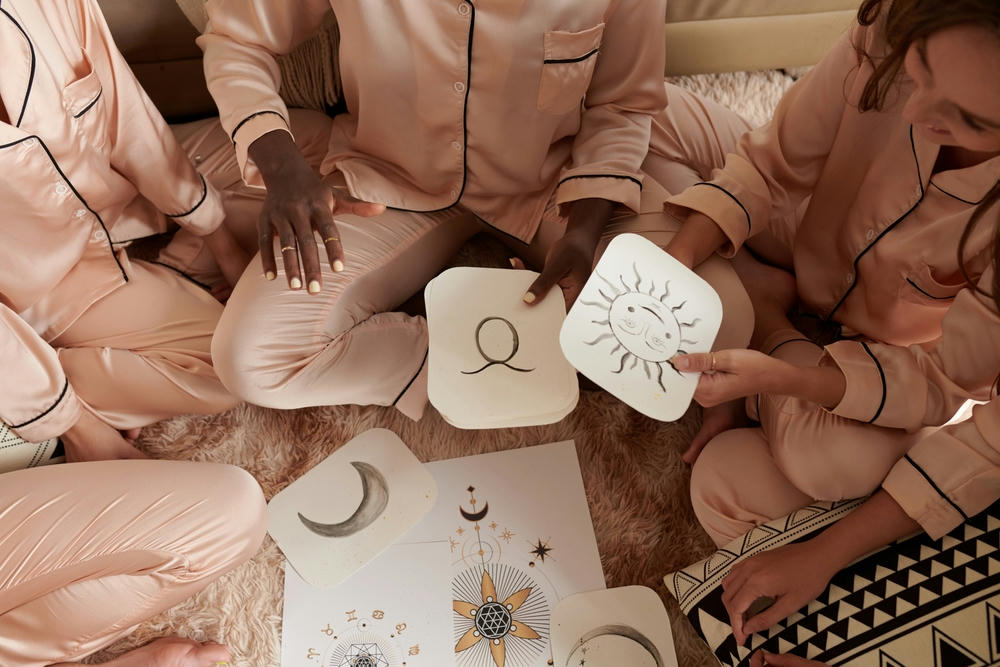 Woman explaining how astrology birth chart works to her friends at a pajama party.