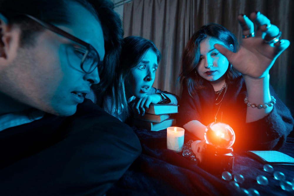 Group of people and a woman fortune teller with a crystal ball.