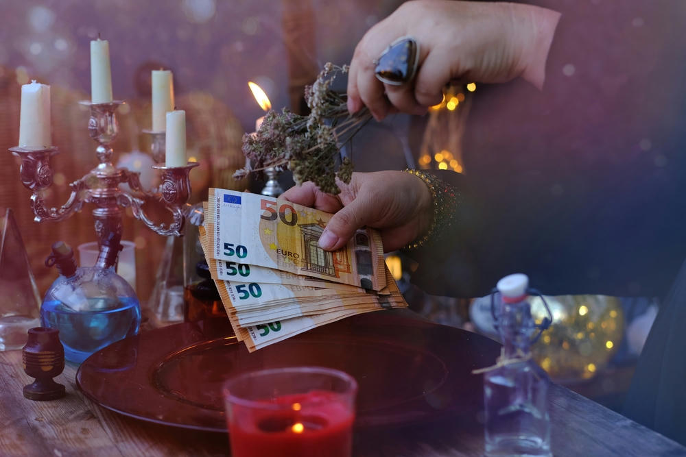 Female hands of psychics doing witchcraft pass banknotes.