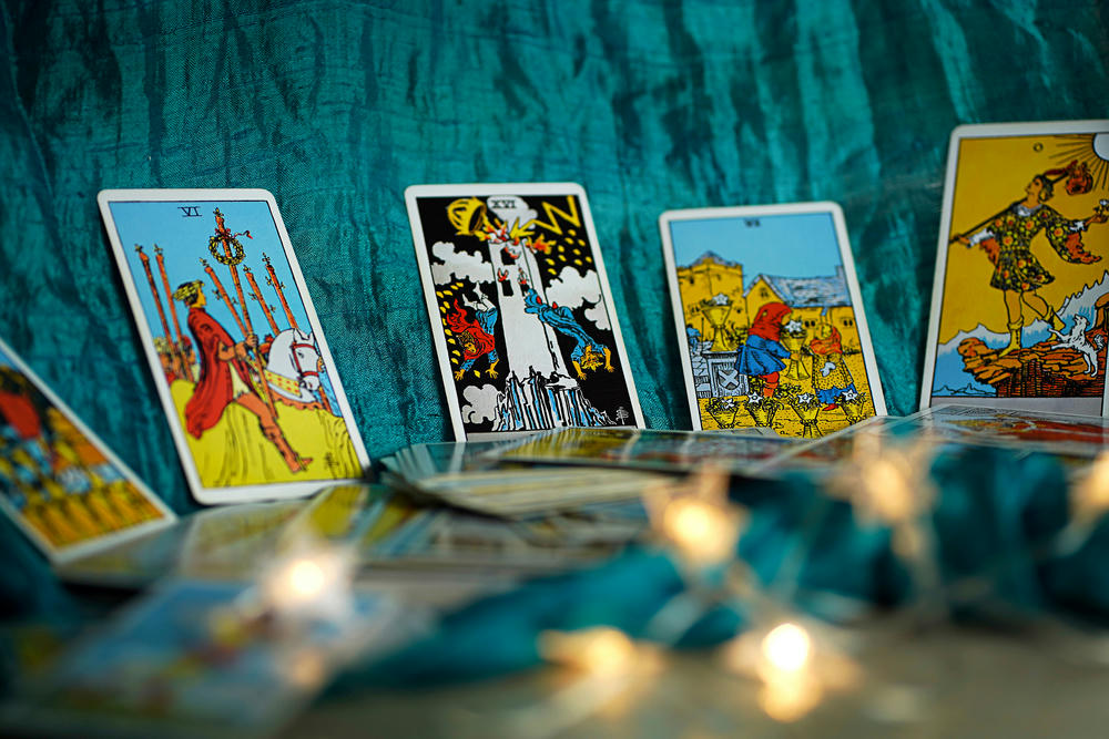 Blurred still life with tarot cards laid on a witch table.