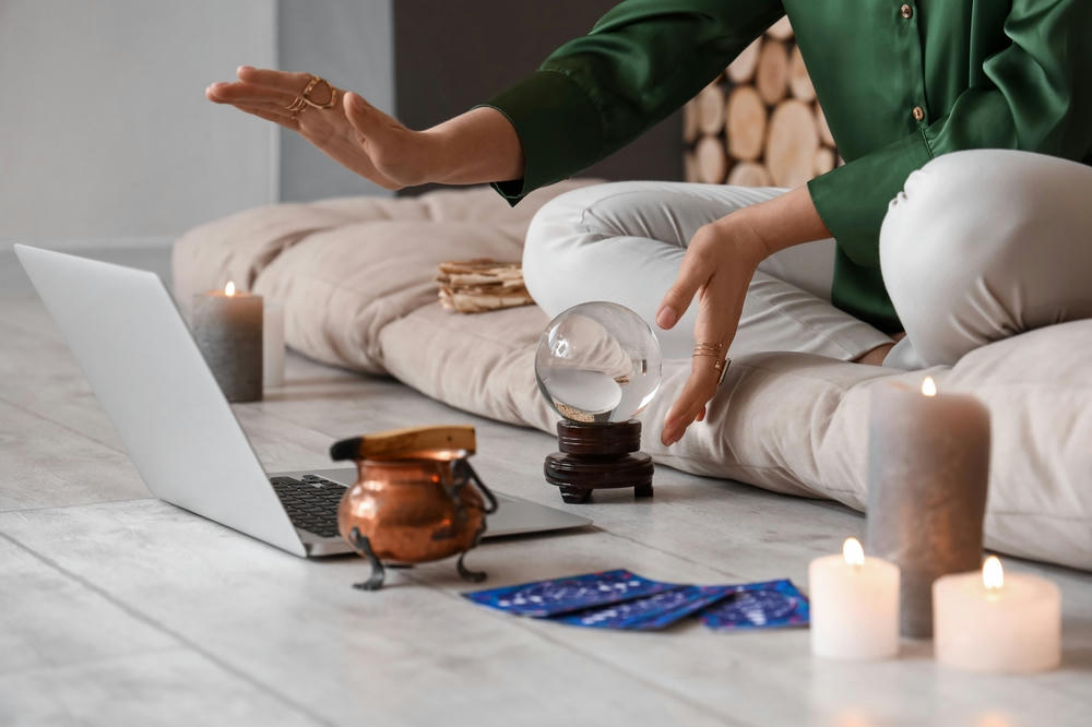 Young clairvoyant with crystal ball recording online at home