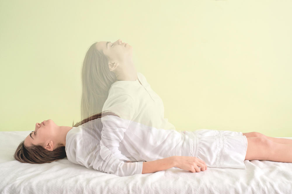Young girl is waking up again as the soul connects with the body demonstrating an out of body experience.