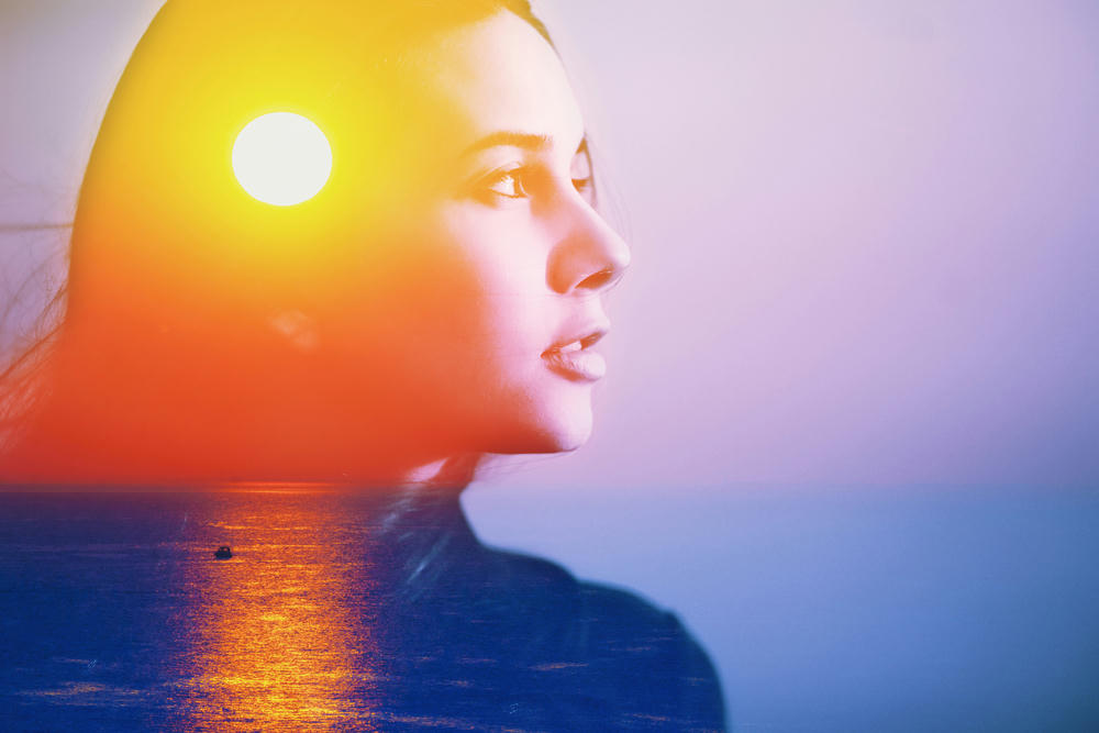 An abstract art portrait of a happy woman, face side portrait looking at the sun, contemplating life.